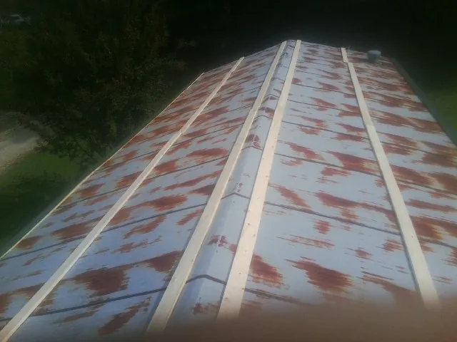 Rusted metal roof panels with new wood purlins before replacement — Storm Damage Roof Repair in Smyrna by Roofing Brothers